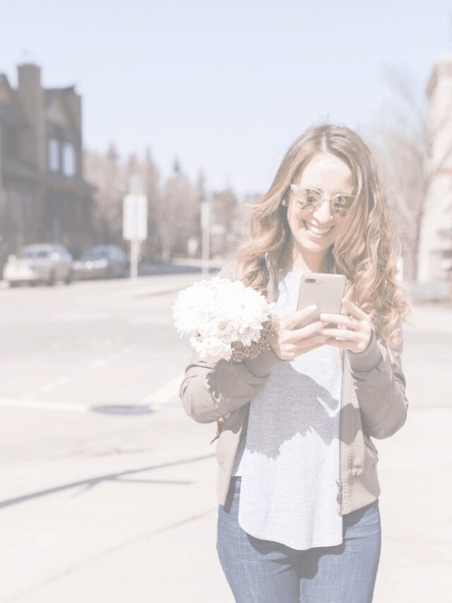 Woman walking on the street looking at her phone