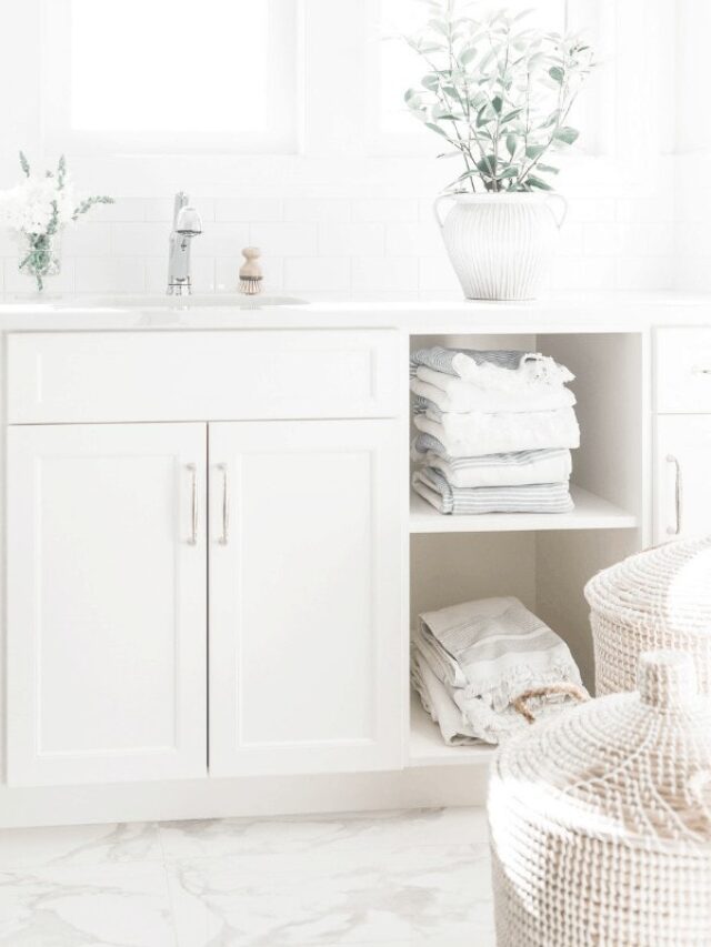 A light and airy image of a bathroom sink and baskets on white shelves