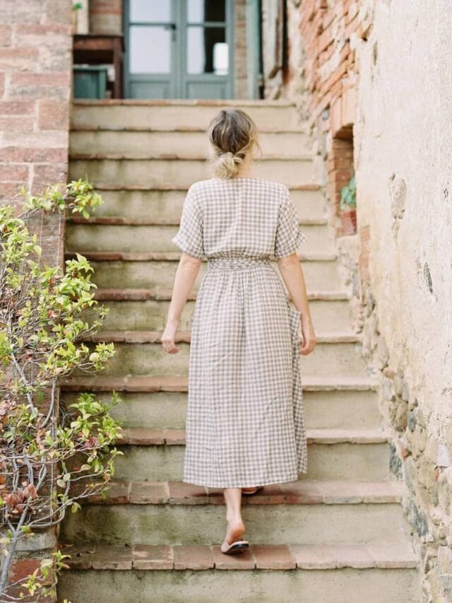 A woman walking up a rustic outdoor staircase.