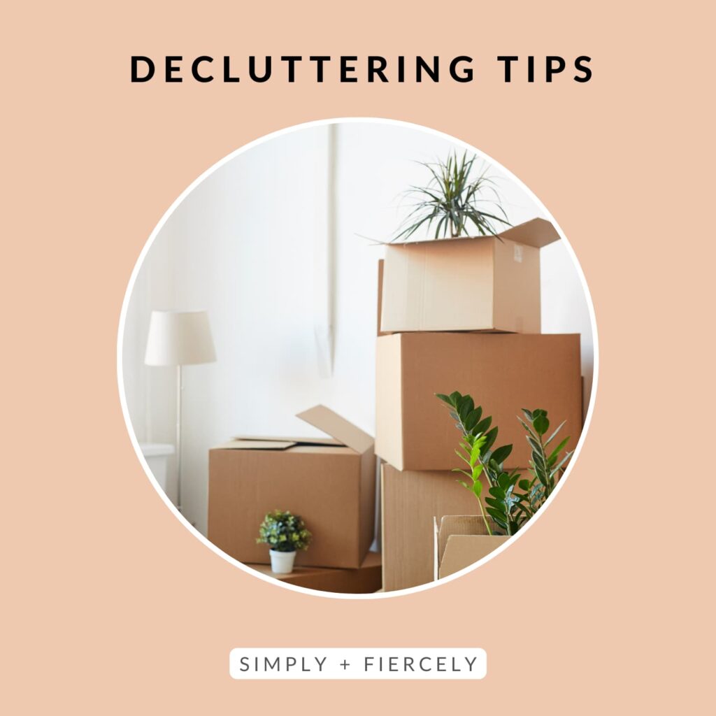 A round pink frame with the text "decluttering tips). Inside the frame is a photo of boxes with plants stacked on top.