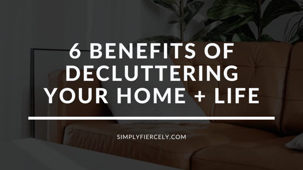 The words "6 Powerful Benefits of Decluttering Your Home + Life" on a translucent black overlay with an image of a sofa and throw blanket in the background