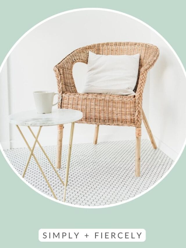 A circular image of a wicker chair that has a throw pillow on it and a small round table with a coffee mug on it on a white tiled floor on a green background with the words Simple Living across the top
