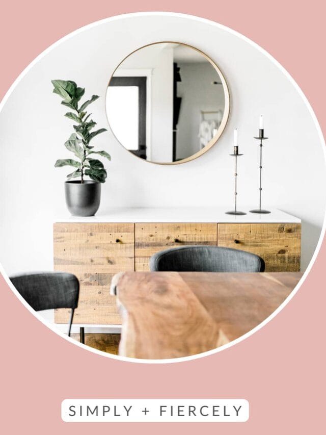 "Decluttering Tips" on a pink background with a round image of a dining room with a wooden buffet, a plant, 2 candle holders and a mirror in the background. There's a wood table and 2 grey chairs in the foreground.