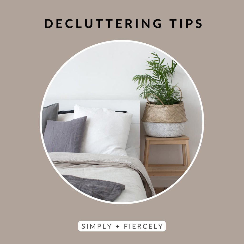 A circular image of a made bed with a plant on a wooden table on top of a taupe background with the words "Decluttering Tips" across the top in black letters.