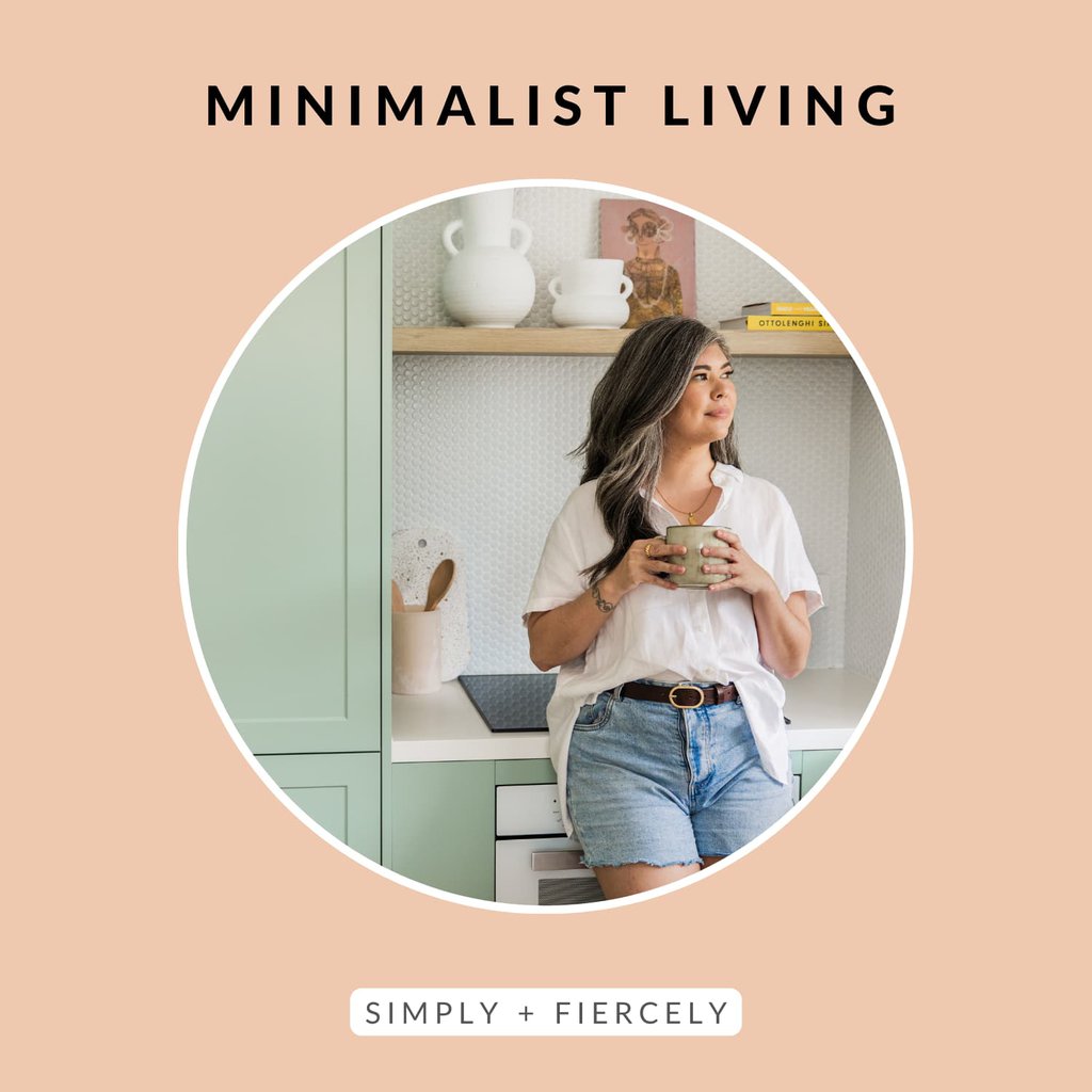 A round image of a woman wearing a white button up top and denim shorts holding a coffee cup leaning on a kitchen counter looking out the window on an orange background with the words Minimalist Living across the top.