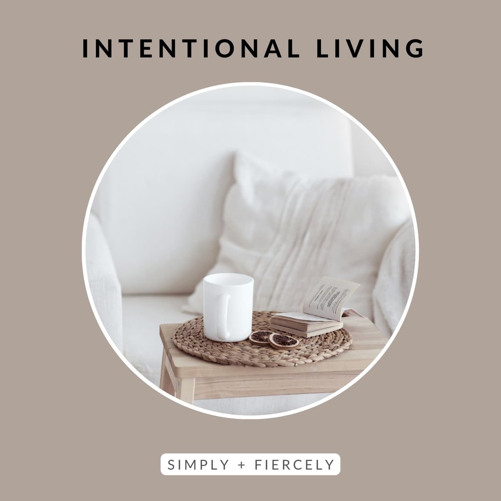 A round image of a table with a coffee cup, orange slice, a book, and a wicker mat on top on a taupe background with the words Intentional Living across the top.