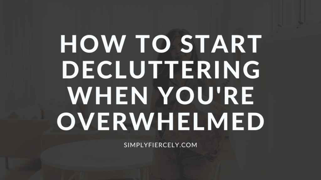 "How To Start Decluttering When You're Simply Overwhelmed" in white text on a translucent black overlay on top of an image of a smiling woman wearing shorts and a sleeveless top holding a basket of books.