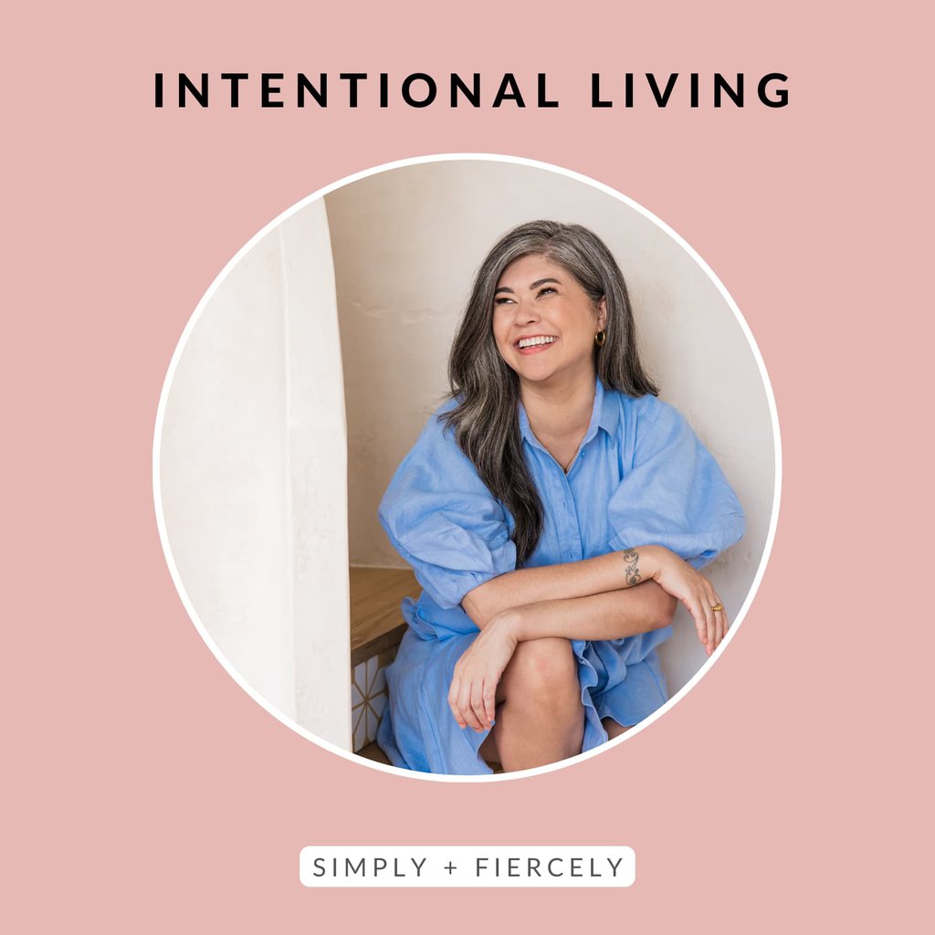 A round image of a smiling woman sitting down wearing a blue dress on a pink background with the words Intentional Living across the topl