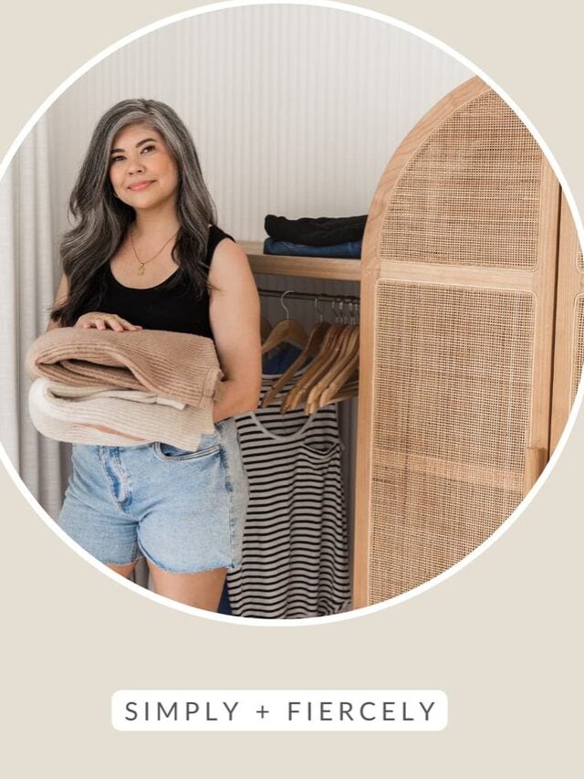 A round image of a smiling woman wearing denim shorts and a black tank top decluttering her closet on a tan background with the words decluttering tips across the top.