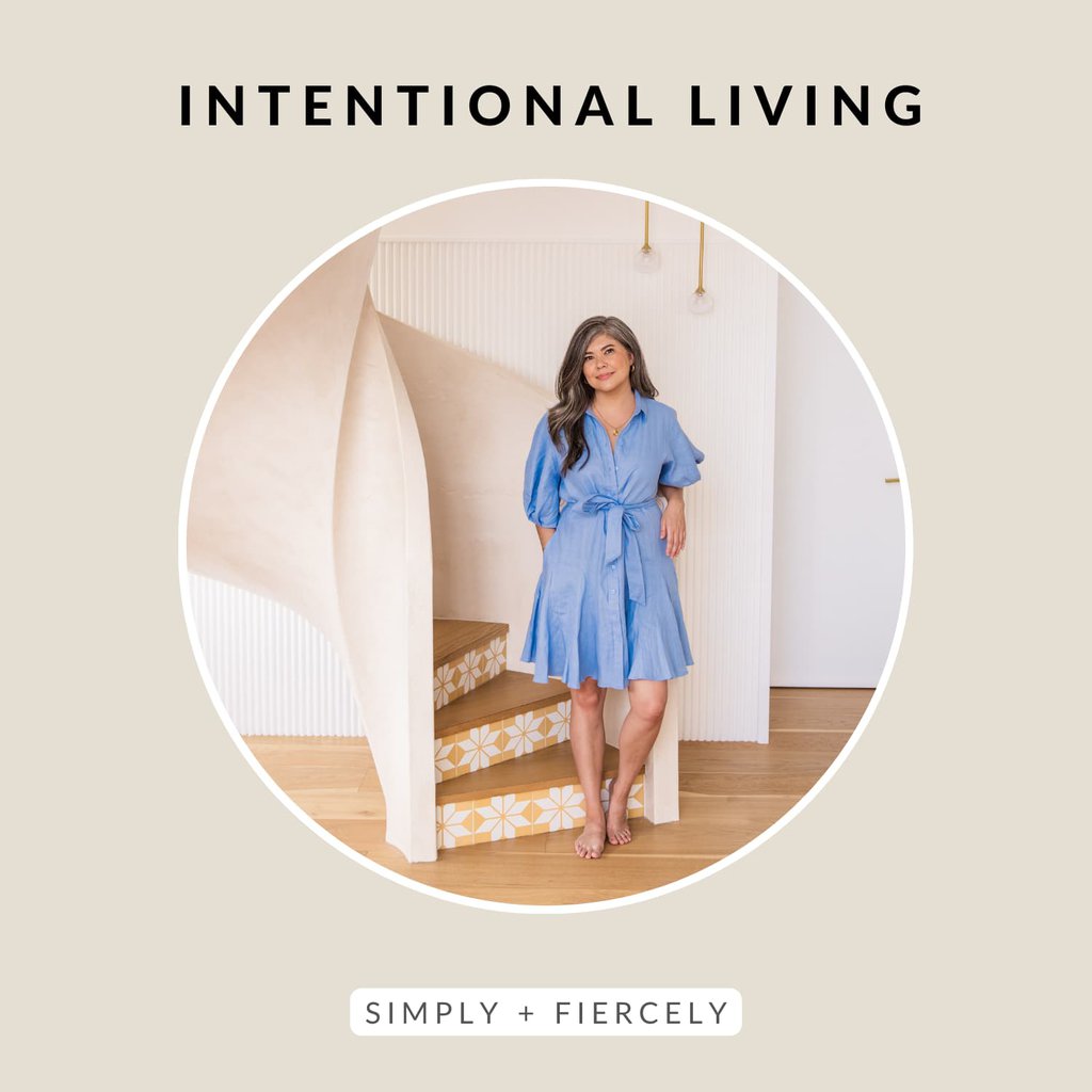 A round image of a woman wearing a blue dress standing in front of a staircase in a beige background with the words Intentional Living across the top.