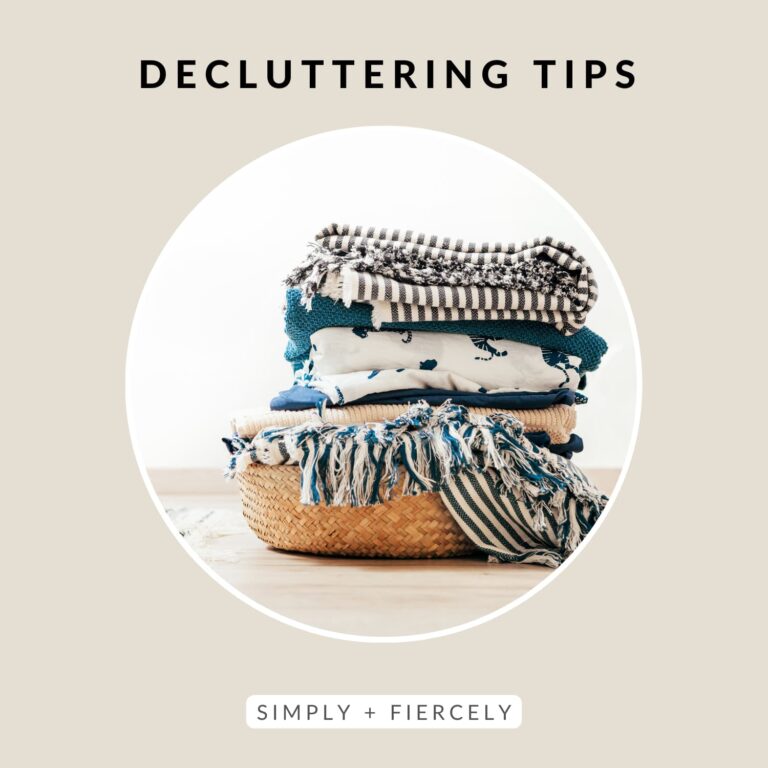 A round image of a wicker basket full of white, grey and blue striped linens on a beige background with the words Decluttering Tips across the top.