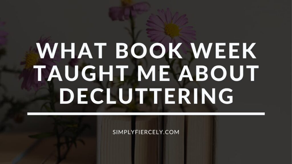 What Book Week Taught Me About Decluttering in white lettering on a translucent black overlay on top of an image of books lined up along a wall with a purple daisy tucked into each book.